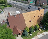 Drone view of crews installing solid roof decking during a Minneapolis church roof replacement