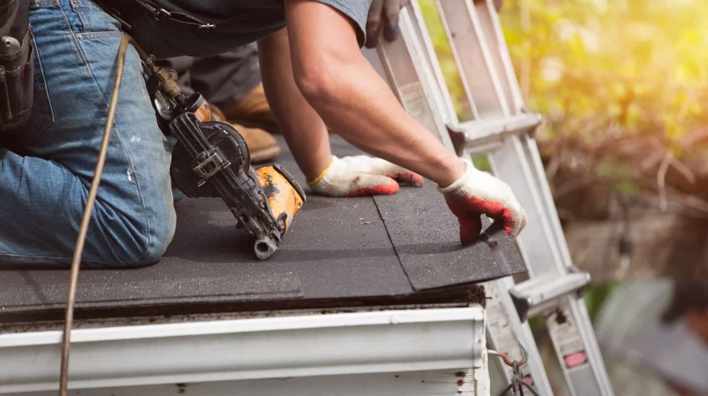 banner roofer installing shingles - closeup